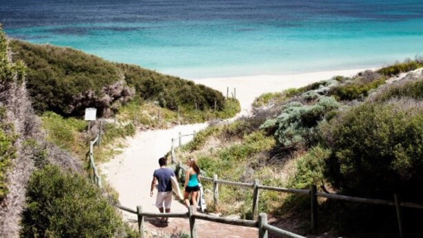 A coastal path leading to a beach with a wooden fence and a sign. - Seashells Yallingup (Yallingup)