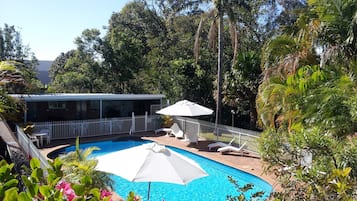 Piscina a l'aire lliure, para-sols i gandules
