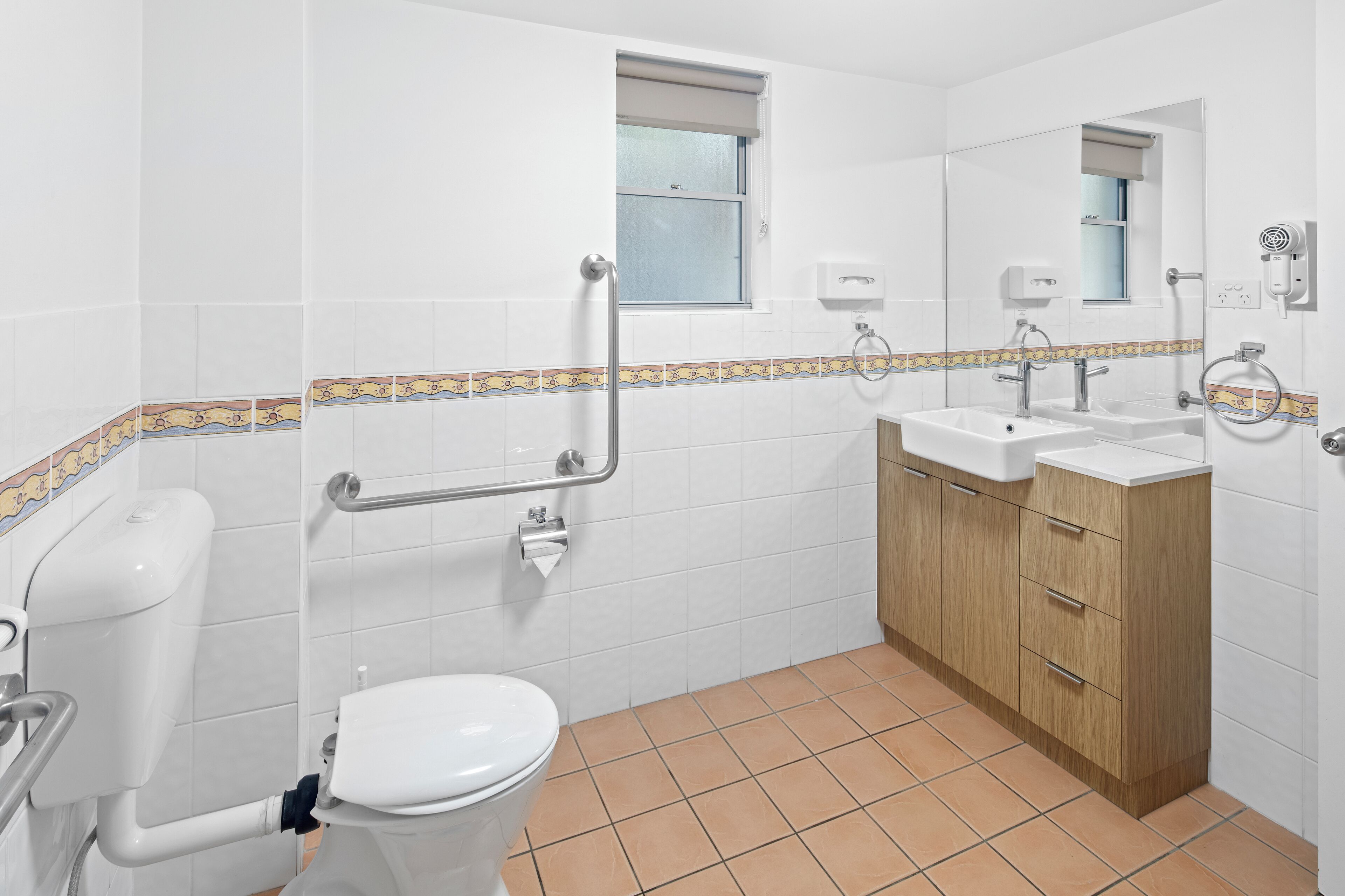 A bathroom with a toilet, sink, and vanity.