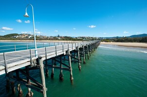 Un muelle de madera que se adentra en el mar, con un farol al final.