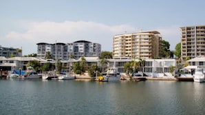 Un port de plaisance où sont amarrés de nombreux bateaux, entouré d’immeubles de grande hauteur dotés de balcons.