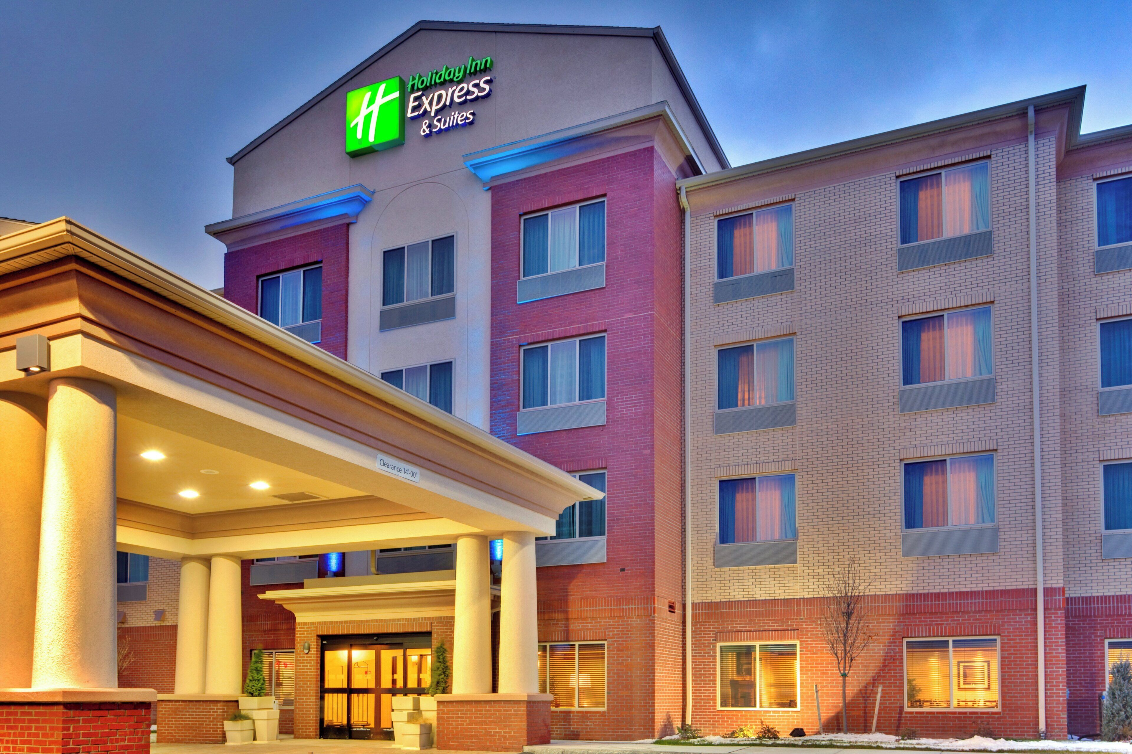 A Holiday Inn Express & Suites building with a covered entrance and multiple windows.