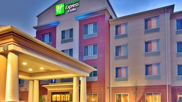 A Holiday Inn Express & Suites building with a covered entrance and multiple windows.