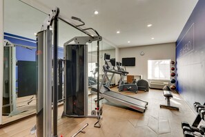 Une salle de sport équipée de machines de cardio, de matériel de musculation et dotée d’un mur avec des miroirs.