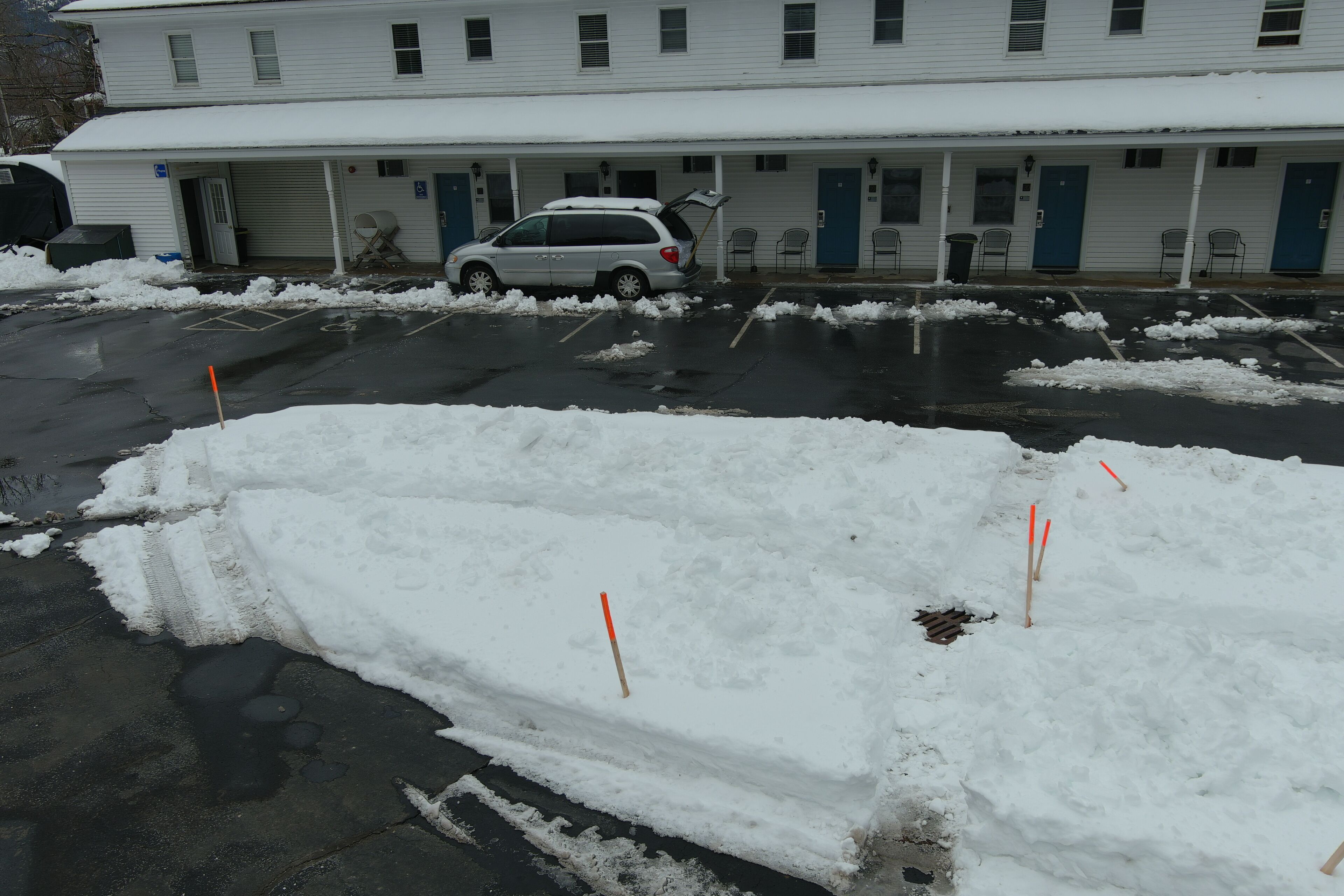 Un hôtel doté d’un parking couvert et dont le terrain est recouvert de neige.