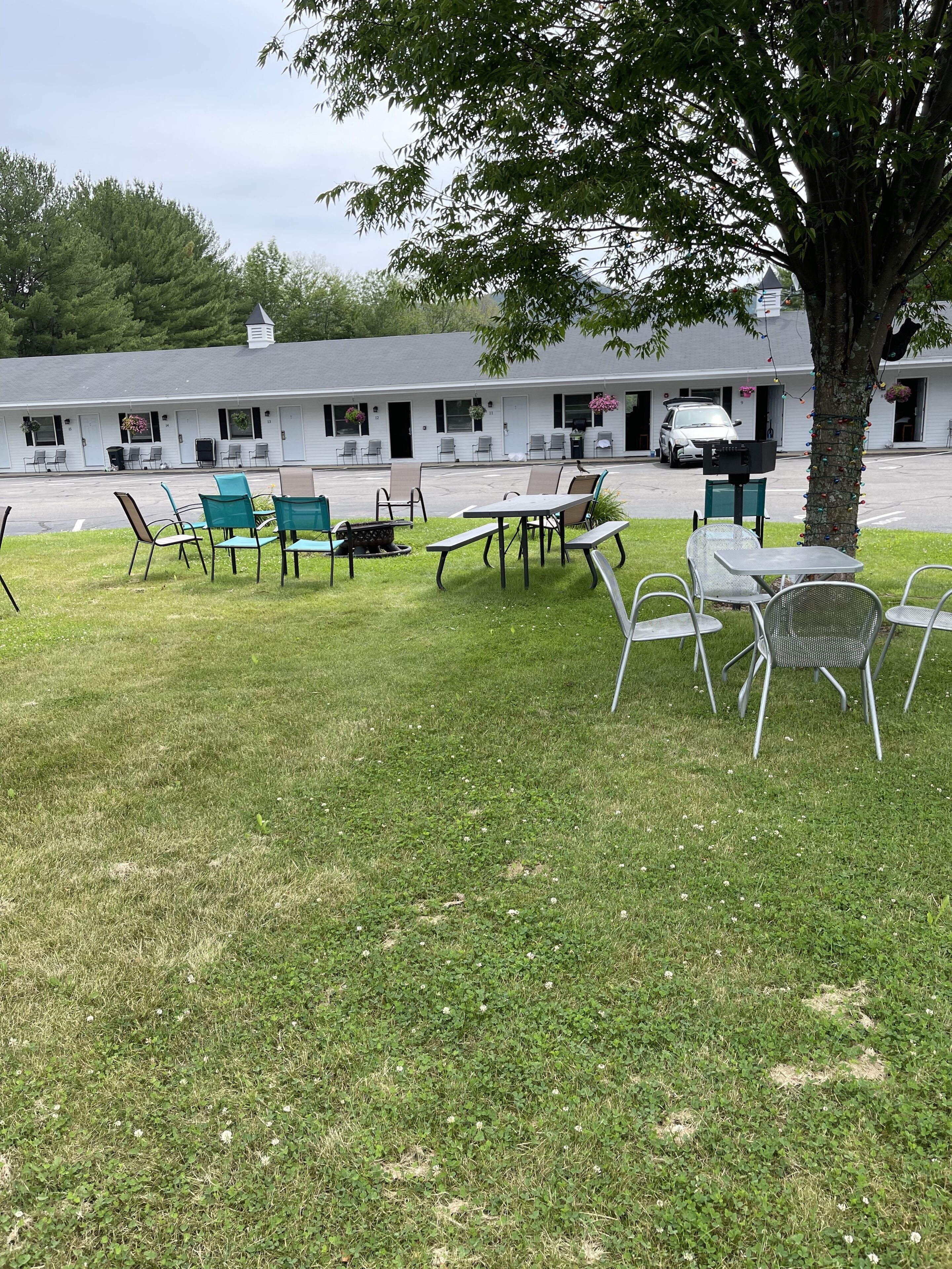 A motel with outdoor seating and a parking lot.