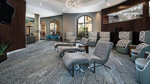 A modern lobby with a seating area, a TV mounted on the wall, and a chandelier. - Courtyard by Marriott San Antonio SeaWorld - Westover Hills (San Antonio)