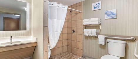 Une salle de bain moderne équipée d’une douche, de toilettes et d’un meuble-lavabo.