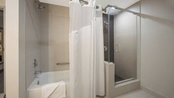 A bathroom with a bathtub, a shower, and a glass-enclosed shower stall.