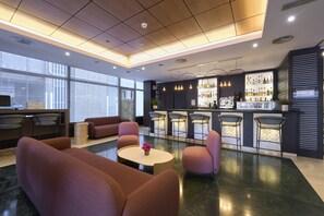 Un hall d’entrée moderne avec des sièges, un bar et un comptoir d’accueil.