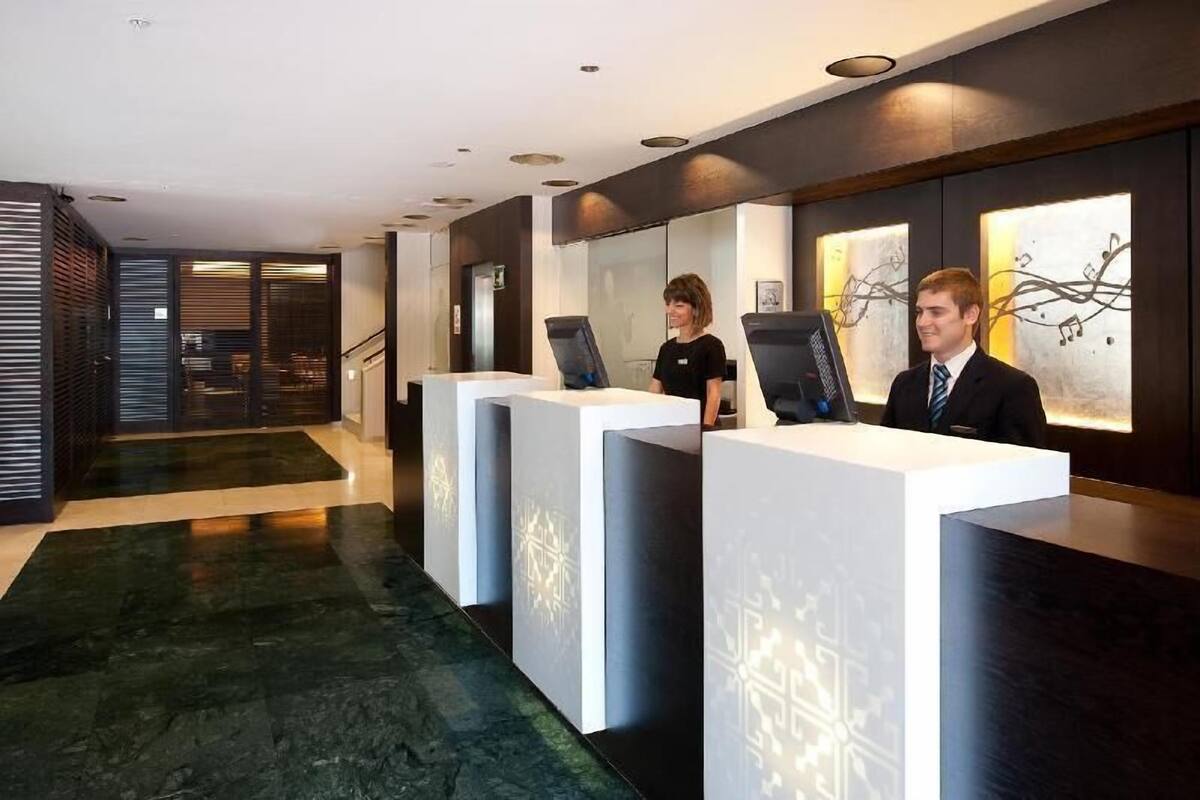 Un espace d’accueil doté de trois postes de réception, d’un design moderne et d’un sol en marbre.