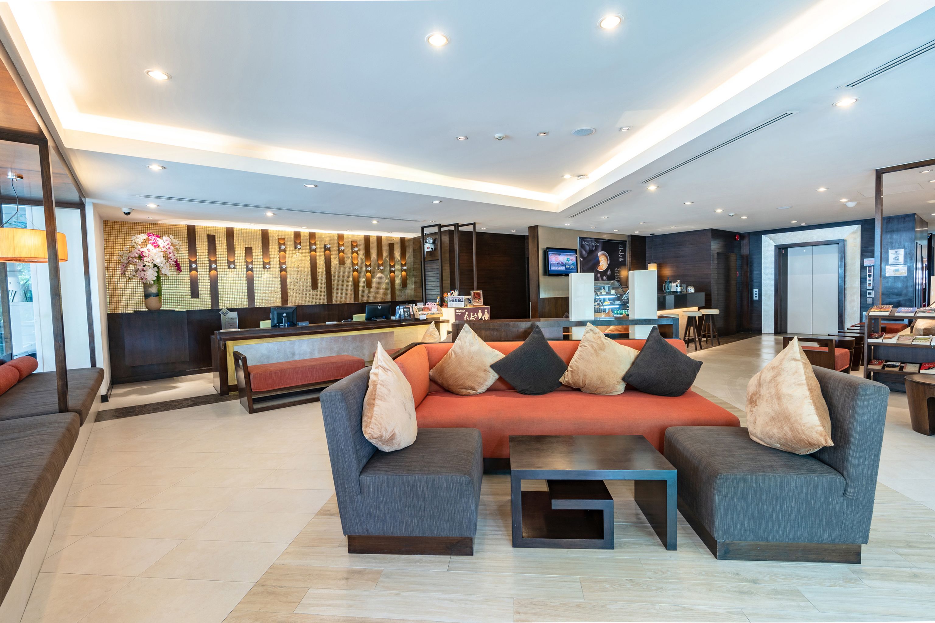 A modern lobby with a sofa, a coffee table, and a reception desk.