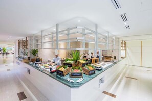 A hotel buffet with various food stations, including a watermelon station, and a clean, modern interior with a glass partition. - A-One Pattaya Beach Resort (Pattaya)