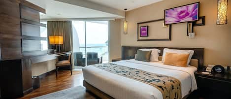 Una habitación de hotel moderna con una cama grande, un escritorio y un balcón.