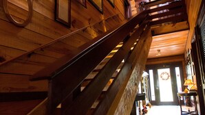 A wooden staircase with a handrail leading to a door with a wreath. - Antietam Overlook Farm (Keedysville)
