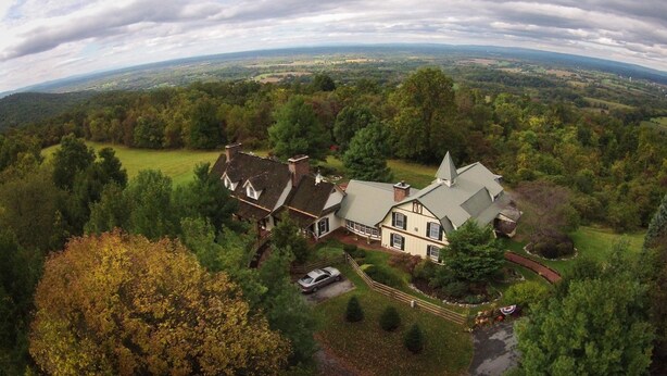 A large house with a prominent tower, surrounded by lush greenery and a vast landscape. - Antietam Overlook Farm (Keedysville)