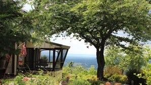A covered outdoor seating area with a view of a lake and mountains. - Antietam Overlook Farm (Keedysville)