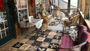 Una habitación acogedora con suelo de cuadros, muebles de madera y un balcón con barandilla.