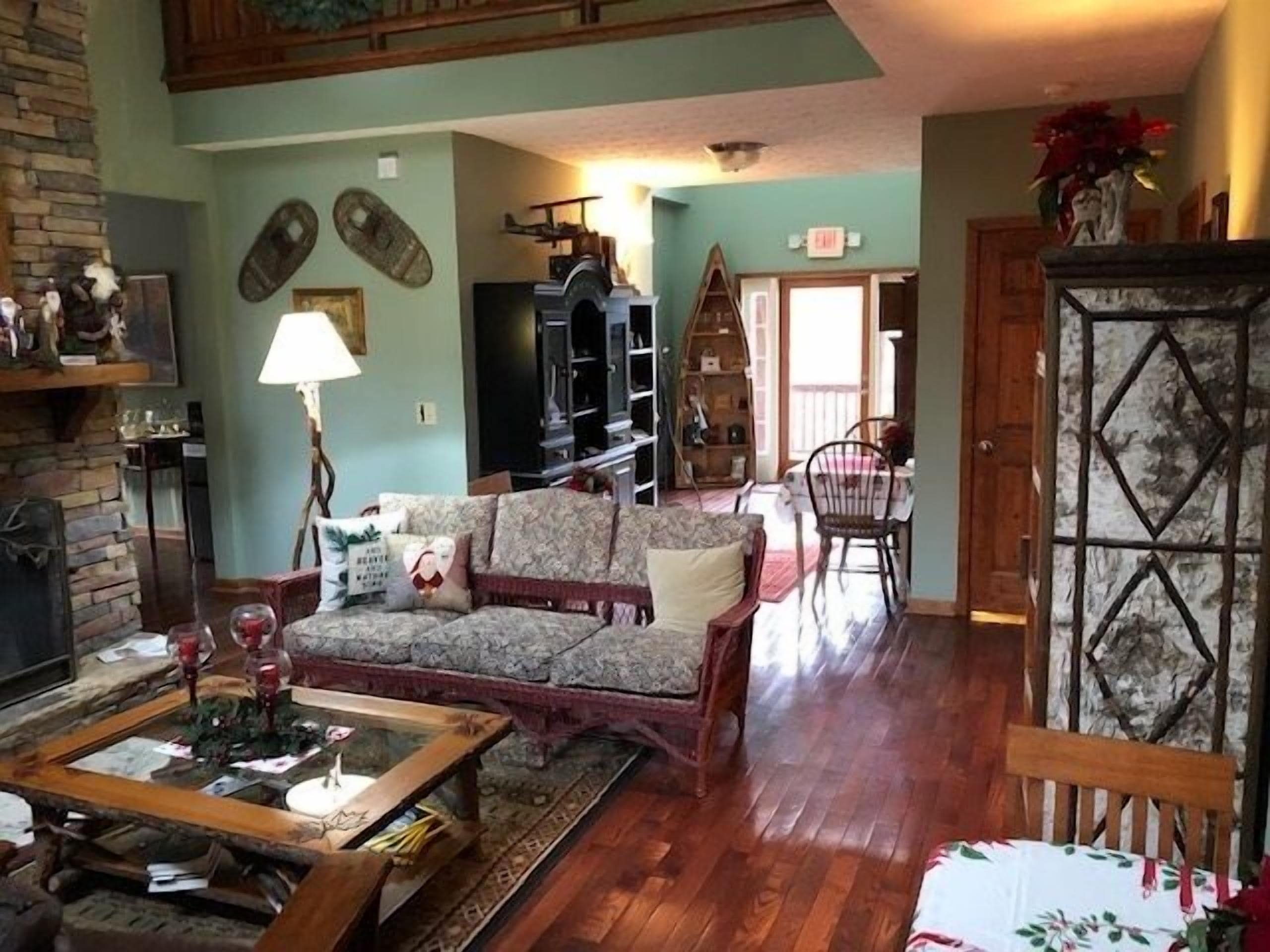 A cozy living room with a fireplace, a dining area with a table and chairs, and a bookshelf.