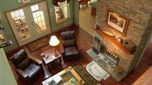 Un espacio lounge acogedor con sillones de cuero, chimenea y una mesa de centro.