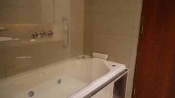 A bathroom with a bathtub, a glass shower enclosure, and a toilet.
