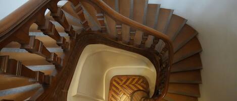 A spiral staircase with wooden steps and a decorative handrail.