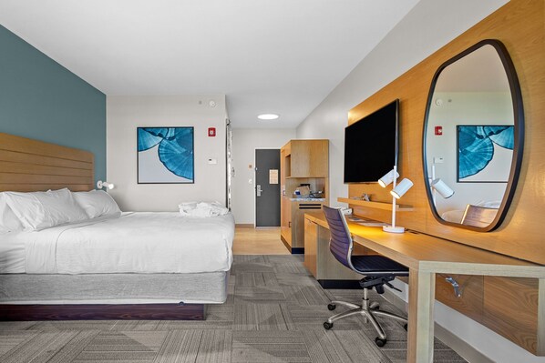 A hotel room with a bed, desk, chair, and a large mirror. - Four Points by Sheraton Punta Gorda Harborside (Punta Gorda)