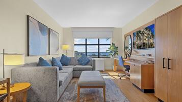 Relax in this stylish living room with a sofa, wooden bench, and sea views.