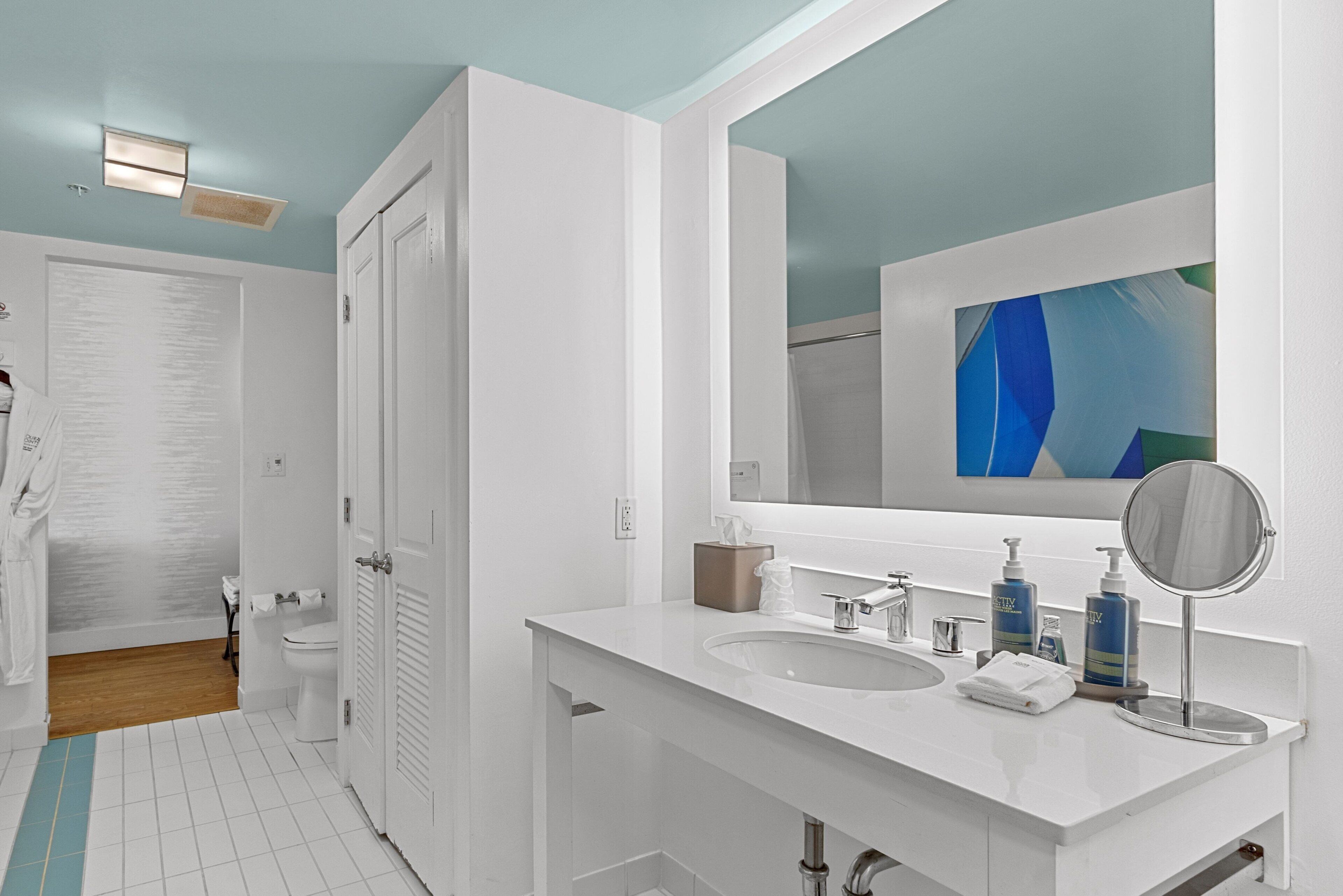 A modern bathroom with two sinks, a large mirror, and a shower area.