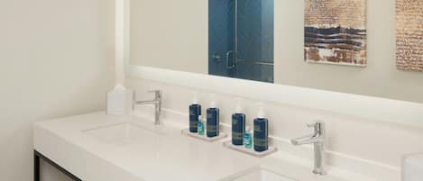 A modern bathroom with two sinks, a large mirror, and a shower door.