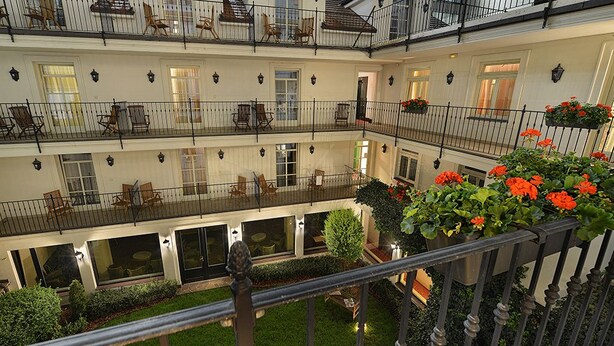 A multi-level hotel with balconies, outdoor seating, and potted plants. - Hotel Angelis (Prague)