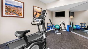 A gym with a treadmill, exercise bike, and various fitness equipment.