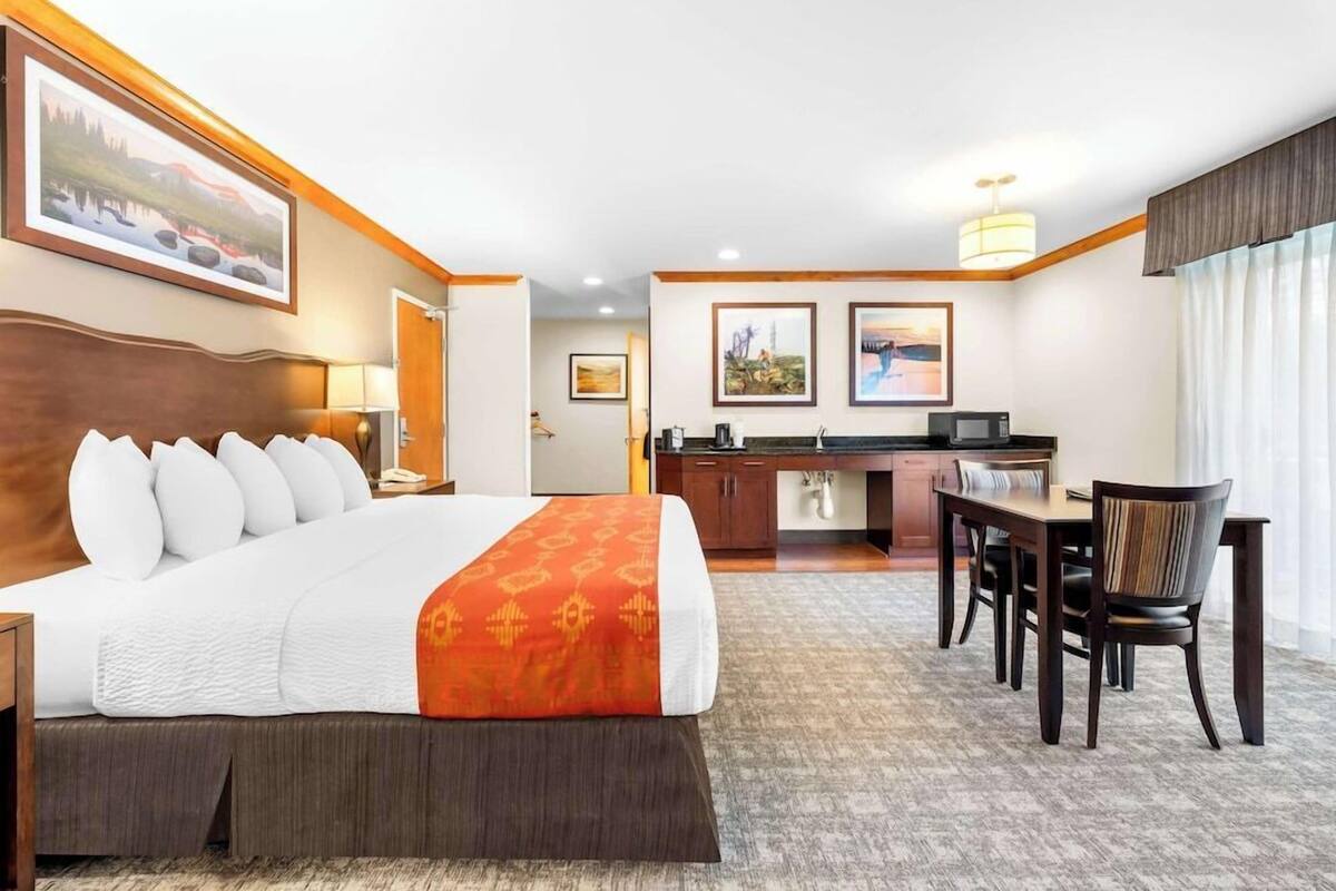 Hotelkamer met een groot bed, een bureau, een stoel, een magnetron en een eettafel.