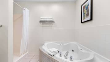 A modern bathroom with a freestanding bathtub, a shower curtain, and a towel rack.