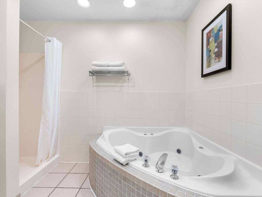 A modern bathroom with a freestanding bathtub, a shower curtain, and a towel rack.