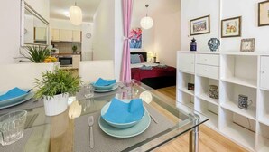 A modern living room with a glass dining table, a sofa, and a bookshelf. - Opera Residence (Budapest)