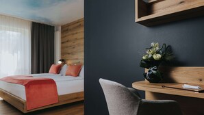 A modern hotel room with a wooden bed, a desk with a chair, and a wall-mounted shelf. - Hotel Drei Quellen Therme (Bad Griesbach im Rottal)