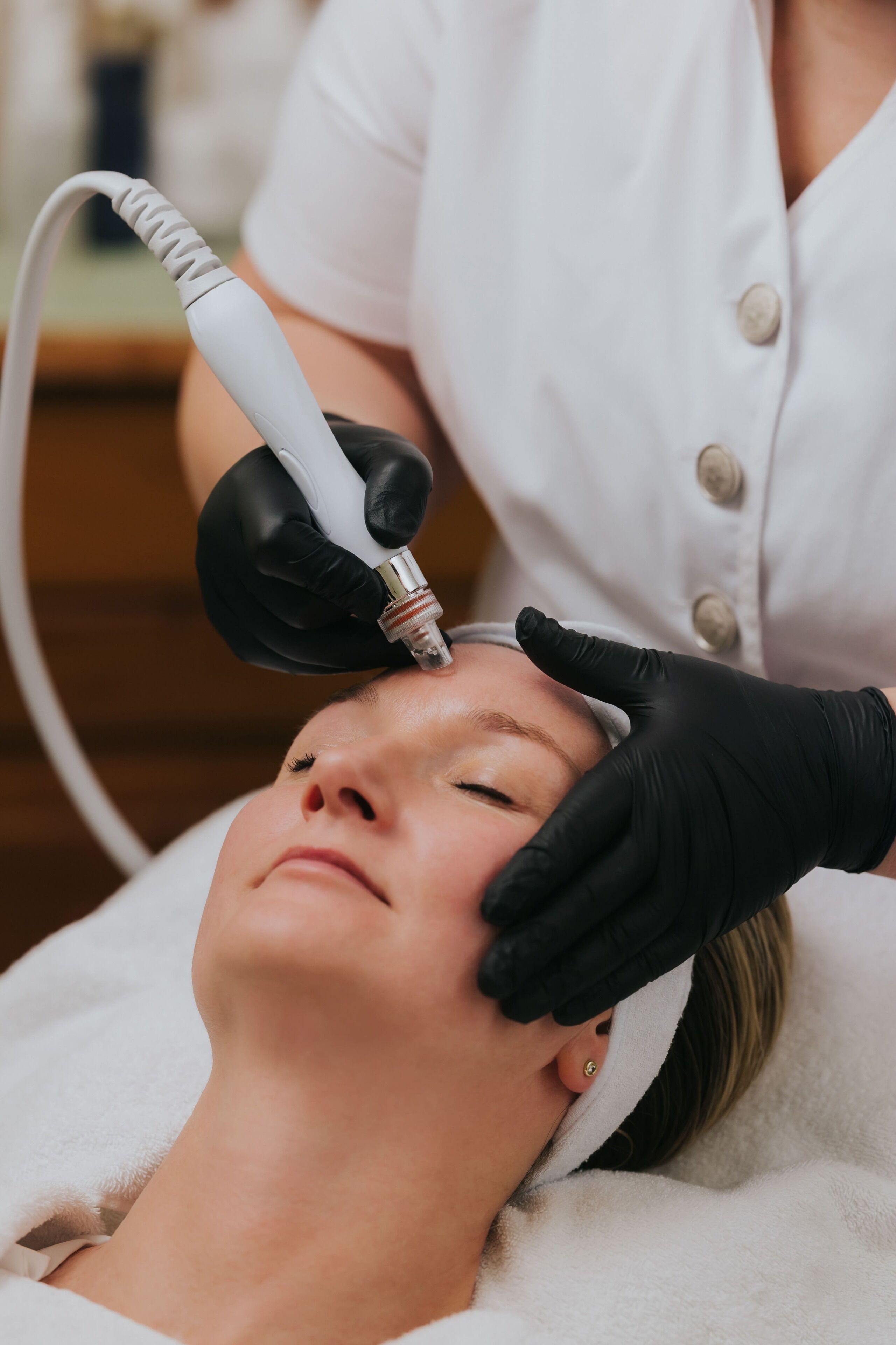 A person lying down with a device being used on their head.