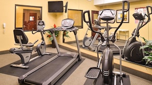 A gym with treadmills, elliptical machines, and stationary bikes.