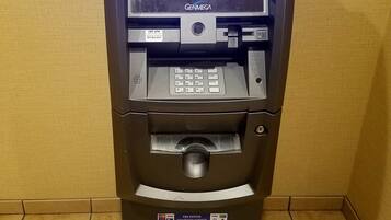 Een geldautomaat met een digitaal scherm, kaartlezer en gelduitgifteopening.
