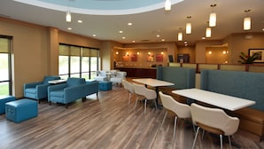 A modern restaurant with blue and white seating, wooden floors, and pendant lighting.