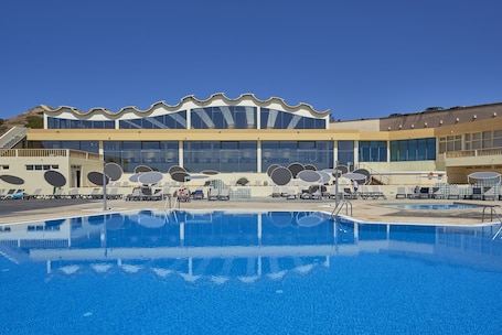 Una piscina techada, 2 piscinas al aire libre, sombrillas