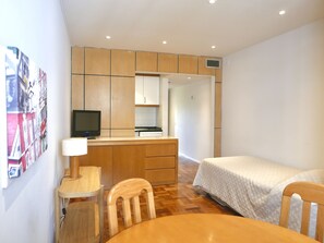 A compact room with a wooden desk, a chair, a bed, and a television. - Lisboa Central Park Hotel Suites & Studios (Lisbon)