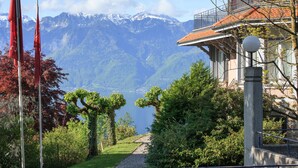 A pathway leading to a building with a mountain view. - Hôtel Préalpina (Chexbres)
