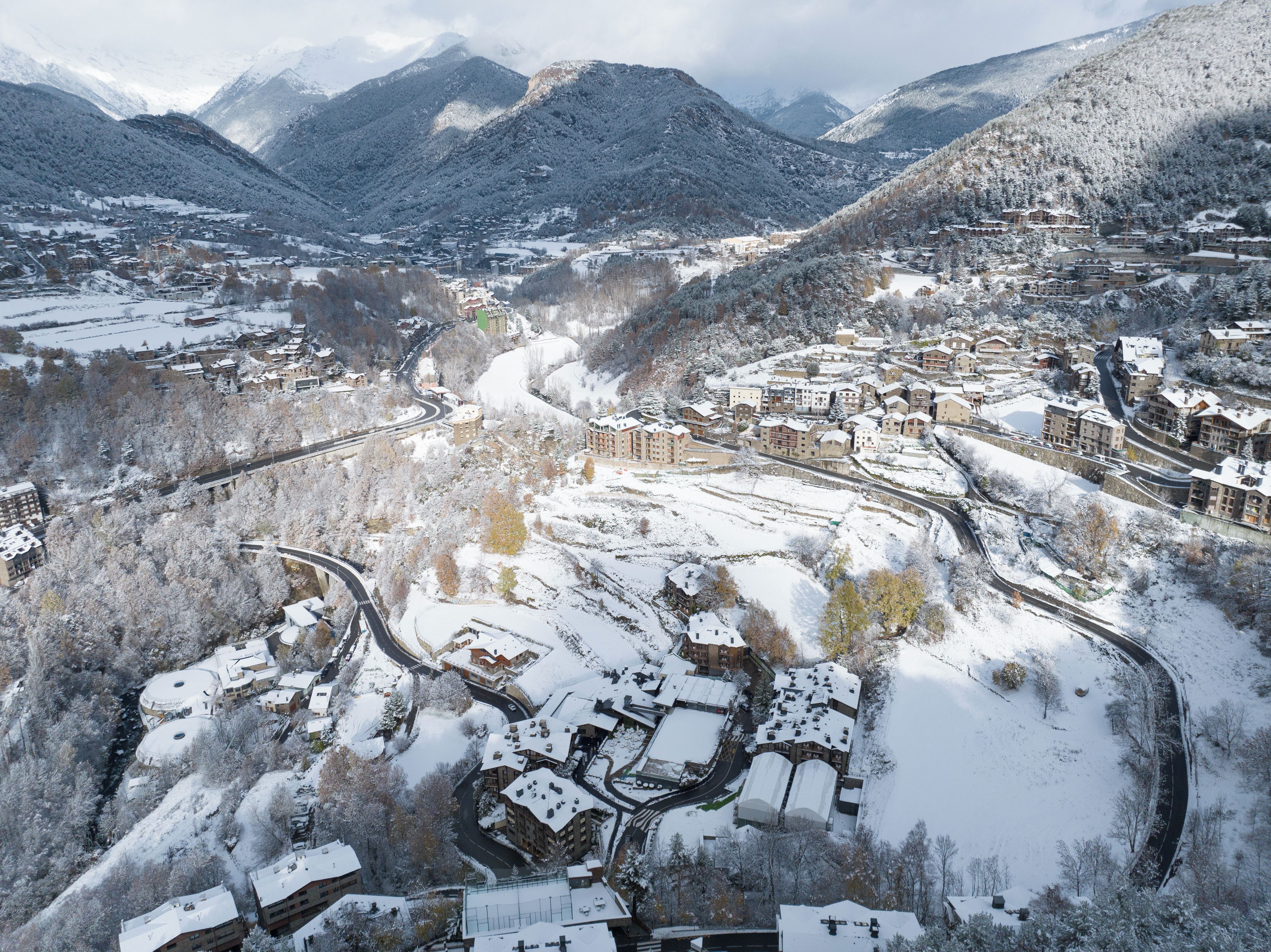 Un pueblo cubierto de nieve con edificios y carreteras sinuosas.