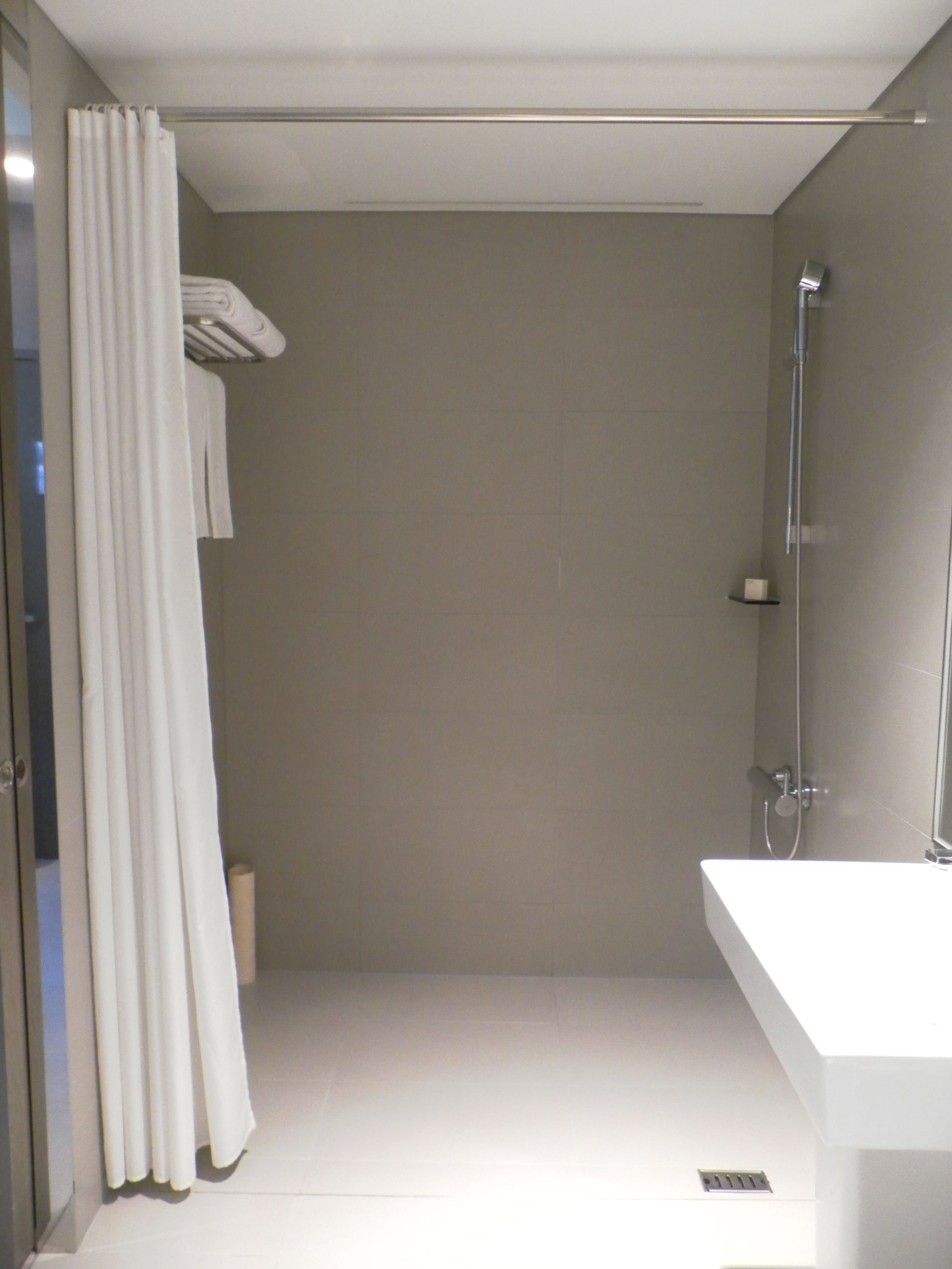A modern bathroom with a shower, a toilet, and a sink.
