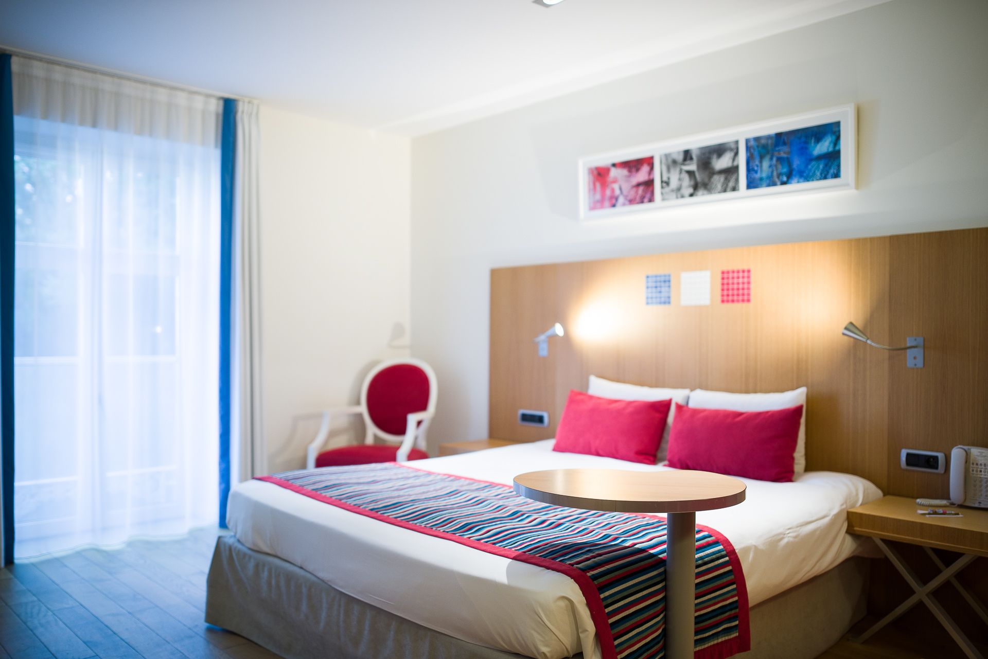 Ein Hotelzimmer mit Bett, Nachttisch, Stuhl und Schreibtisch.