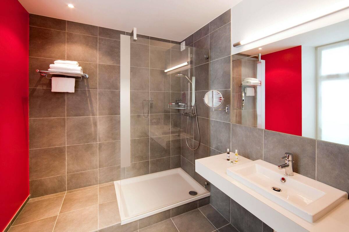 Un baño moderno con cabina de ducha, bañera y tocador con espejo.