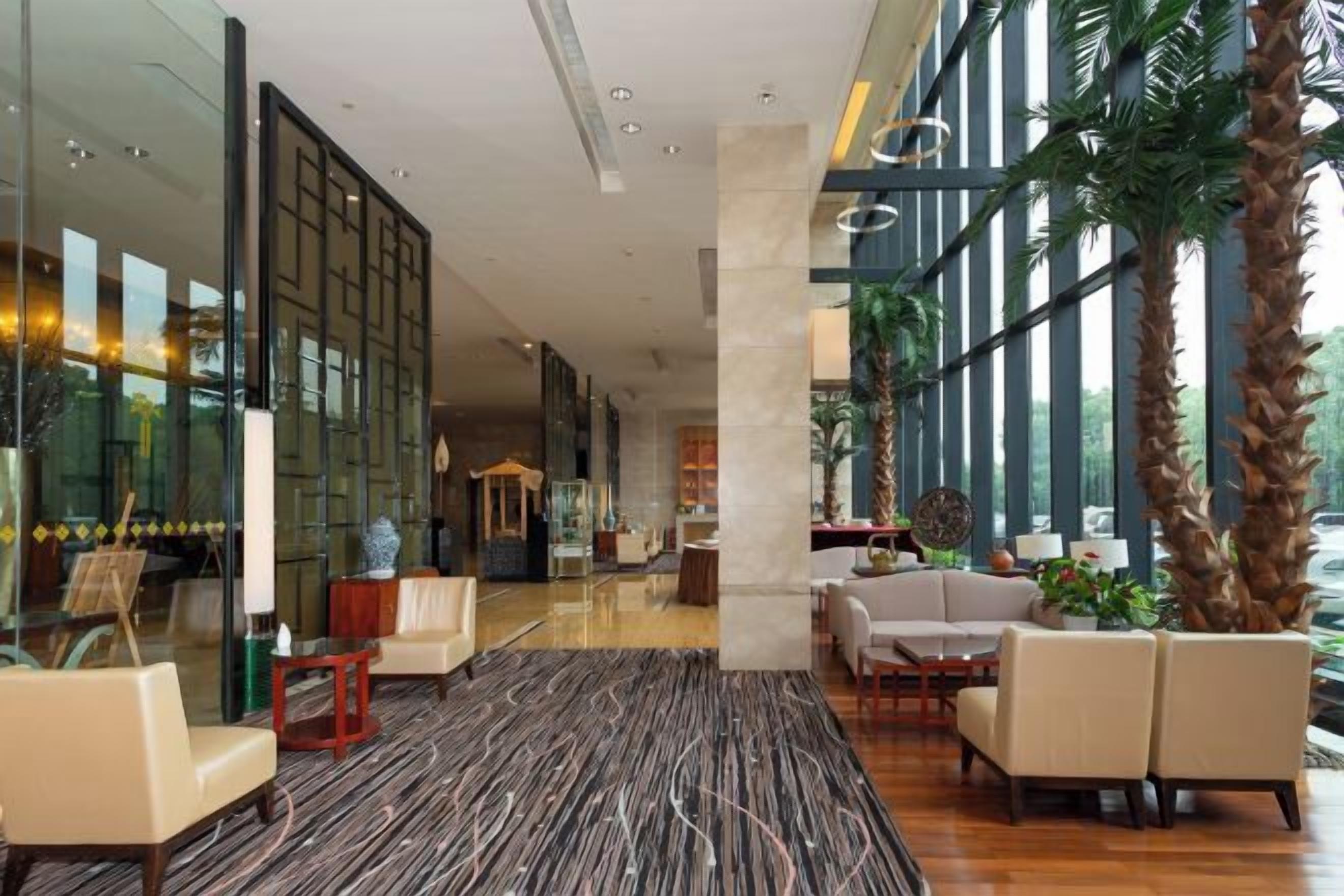 A spacious lobby with seating areas, a reception desk, and large windows allowing natural light.