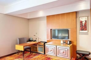 A hotel room with a wooden cabinet, a flat-screen TV, a desk, and a chair. - Jinling Lakeview Hotel (Wuxi)